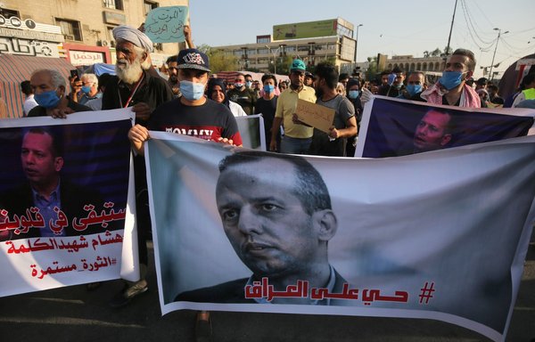 Iraqi demonstrators stage a symbolic funeral for slain Iraqi extremism expert Hisham al-Hashemi, who was shot dead the day before outside his house in the Iraqi capital, on July 7, 2020, at Baghdad's Tahrir square. [Ahmad al-Rubaye/AFP]