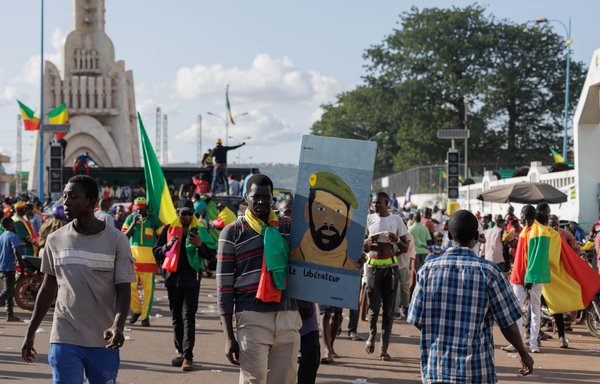 A man holds a picture of Mali's interim president and junta leader during Independence Day Celebrations in Bamako on September 22. [Ousmane Makaveli/AFP]