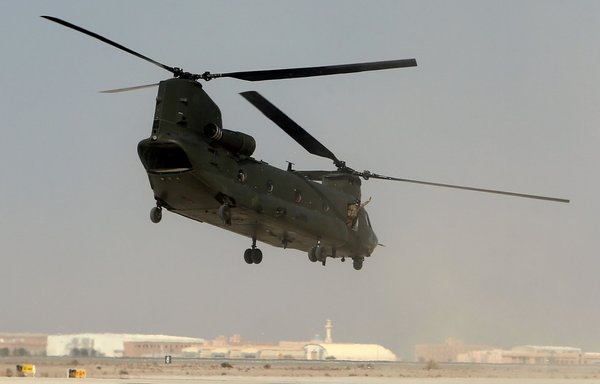 A soldier gestures from a Chinook CH-47 helicopter during the joint British-Omani military exercise, Saif Sareea 3 (Swift Sword 3), in Musannah air base, west of Oman's capital Muscat on October 26, 2018. [Mohammed Mahjoub/AFP]