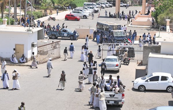 Sudanese Beja tribesmen gather near army vehicles securing the compound of a hotel hosting the UN special representative for Sudan, on May 17, in Port Sudan. [AFP]
