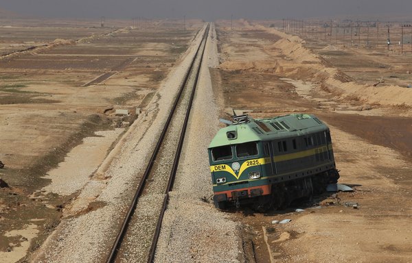 A picture taken November 12, 2018, shows a derailed train left on the side of the track in Anbar province, Iraq, along the frontier with Syria. [Ahmad al-Rubaye/AFP]