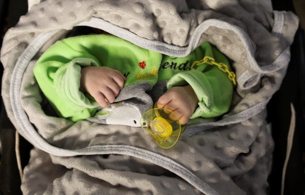 A picture taken on April 30 shows a baby in a crib at the 'Child Houses' centre in Idlib which shelters Syrian unaccompanied children and those of unknown parentage. [Omar Haj Kadour/AFP]
