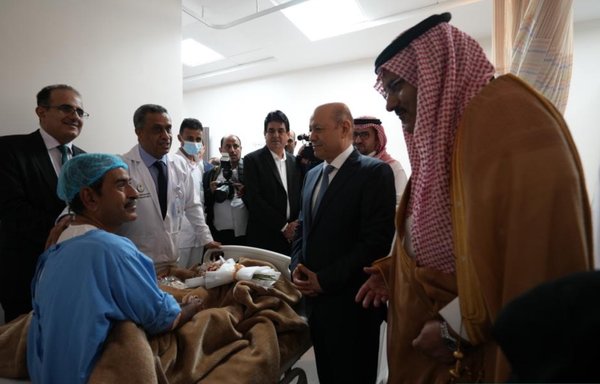 Yemeni Presidential Command Council chairman Rashad al-Alimi, Saudi Development and Reconstruction Programme for Yemen general supervisor Mohammed Al Jaber and other officials speak with a patient during the inauguration of the Aden General Hospital. [Saudi Development and Reconstruction Programme for Yemen]