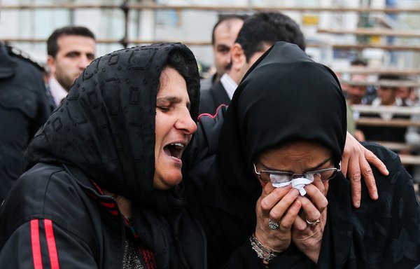 The mother of an Iranian man Balal (L), who killed a fellow Iranian Abdolah Hosseinzadeh in a street fight with a knife in 2007, cries with the mother of Hosseinzadeh, Samereh Alinejad, after she forgave Balal, giving him an emotional slap prior to removing the noose around his neck in the gallows during his execution ceremony in the northern city of Noor on April 15, 2014. [Arash Khamooshi/ISNA/AFP]