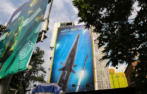 A giant billboard bearing a picture of the Fattah missile, which reads '400 seconds to Tel Aviv' in Farsi, Hebrew and Arabic, covers the side of a building in Tehran on June 7. [Atta Kenare/AFP]