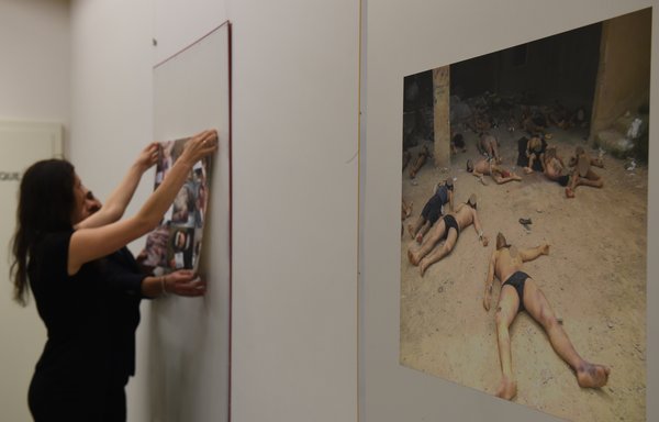 Members of the Syrian Organisation for the Victims of War display pictures documenting the torture of detainees inside the regime's prisons and detention centres, on March 17, 2016, in Geneva. The photographs were taken by a former military policeman of the Syrian army, known as 'Caesar', who defected and fled Syria in 2013. [Philippe Desmazes/AFP]