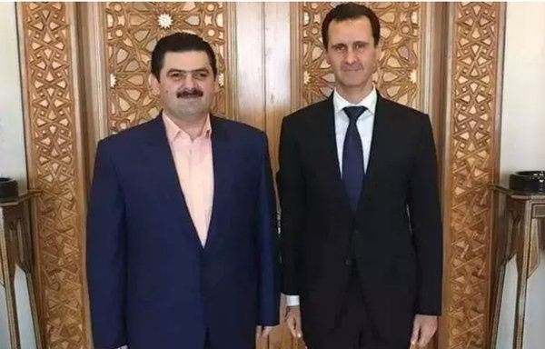 In this undated file photo, Hussam Qaterji, who now heads the Qaterji militia, stands with Syrian president Bashar al-Assad. [Al-Maham/Facebook]