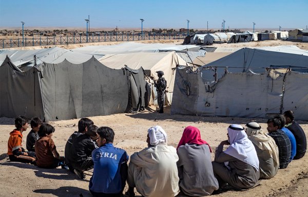 عنصر من قوات الأسايش الكردية السورية يؤمن الحراسة خلال عملية تفتيش للخيم في مخيم الهول الذي يديره الأكراد ويحتجز فيه أقارب مقاتلين يشتبه بانتمائهم إلى داعش وذلك يوم 28 آب/أغسطس ضمن حملة أمنية شنتها قوات سوريا الديموقراطية ضد خلايا داعش النائمة في المخيم. [دليل سليمان/وكالة الصحافة الفرنسية]