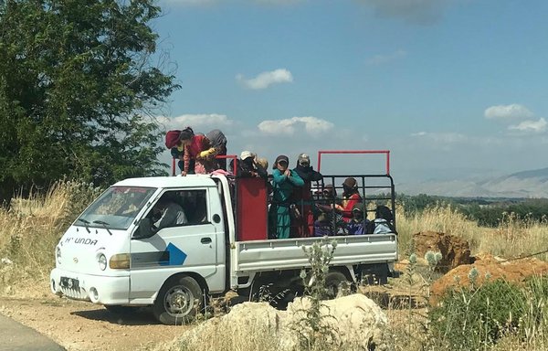 Labourers leave aboard a bus after a long and hard day of harvesting the potato crop in Amiq. [Nohad Topalian/Al-Mashareq]