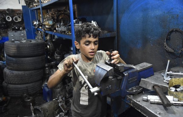 Teenage Syrian refugee Abdel Kader Al-Shami works in a tire shop in Sin al-Fil, Lebanon, after the economic crisis and his family's dire conditions forced to stop his education and take up a job. [Ziad Hatem/Al-Mashareq]