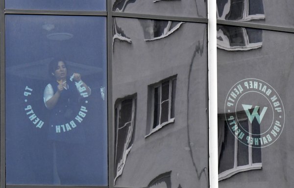 Employees remove the Wagner Group's logos from their closed office in St. Petersburg on July 2. [Olga Maltseva/AFP]