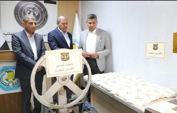 Iraqi officials examine seized drugs and a tablet press machine found in a Captagon pill factory in the the al-Muthanna provincial capital of Samawah. [Courtesy of Saad Maan]