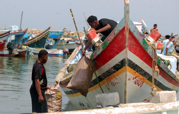 Fishermen bring their catch to sell at a fish market in the Red Sea port city of al-Hodeidah on July 16. [Mohammed Huwais/AFP]