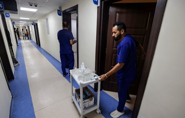 Health workers prepare to distribute medications to patients undergoing treatment for drug addiction at Al-Canal Centre for Social Rehabilitation in Baghdad on July 11. [Ahmad al-Rubaye/AFP]