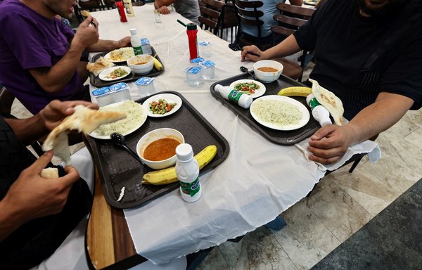 Patients undergoing treatment for drug addiction eat lunch at Al-Canal Centre for Social Rehabilitation in Baghdad on July 11. [Ahmad al-Rubaye/AFP]