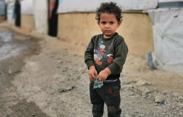 A Syrian refugee child stands outside a makeshift dwelling at a camp in the Lebanese border town of Arsal on July 24. [Voice of Syrian Refugees-Lebanon]