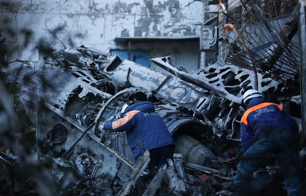 Russian Emergencies personnel remove the wreckage of a Sukhoi Su-34 military jet from its crash site in the courtyard of a residential area in the town of Yeysk in southwestern Russia on October 18. Russia said a 'technical malfunction' probably caused a jet to crash into a block of flats in Yeysk, near Ukraine. [AFP]