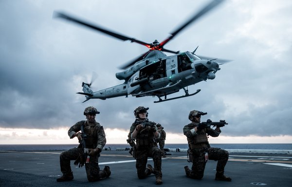 US Marines set security while conducting a fast-rope insertion from a UH-1Y Venom during a visit, board, search and seizure training aboard the amphibious assault ship USS Bataan in the Atlantic Ocean July 19. Fast-roping is a tactical maneuver used to quickly insert troops into austere terrain in which a helicopter may not be able to land. [US Marine Corps]