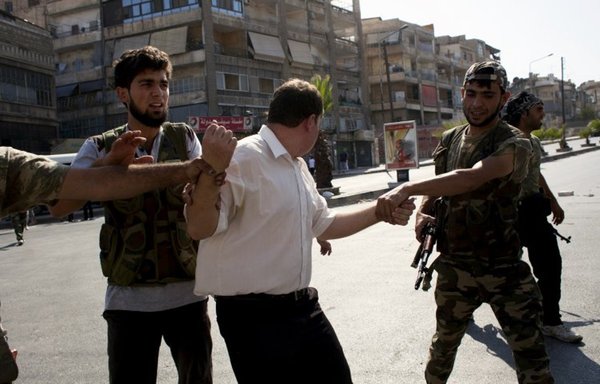 Syrian opposition fighters detain a man they allege is a member of the 'shabiha', or pro-regime militia, in Aleppo on August 12, 2012. [Achilleas Zavallis/AFP]