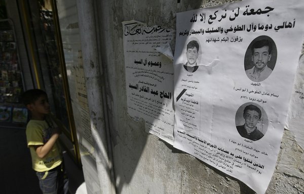 An obituary announcement for Syrian 'martyrs' killed in confrontations with 'criminal gangs and al-Assad shabiha militiamen' is hung on a wall in Duma, a northeastern suburb of Damascus, on August 29, 2011. [Joseph Eid/AFP]