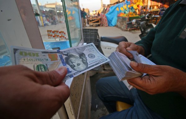 An Iraqi man changes US dollars for Iranian rials in Basra on November 6, 2018. [Haidar Mohammed Ali/AFP]
