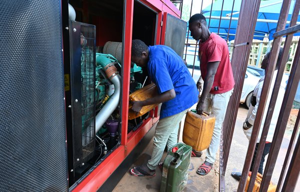 Men pour diesel fuel into a generator in Niamey, Niger, on August 7. Nigeria announced August 2 it was cutting off electricity supplies to its neighbor, in line with the sanctions decided by Niger's West African neighbors. [AFP]