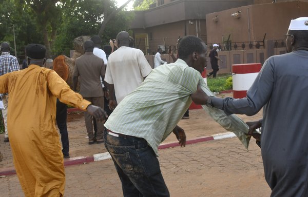 An injured demonstrator in Niamey, Niger, is assisted after warning shots were fired during a protest July 26 against the detention of Nigerien President Mohamed Bazoum by the Presidential Guard that day. [AFP]