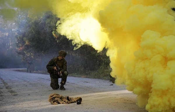 A US Marine checks on his team members during a casualty evacuation drill at Camp Lejeune in North Carolina December 10, 2015. The Marine was part of a II MEF Security Assistance Liaison Team that underwent training to improve its ability to work with coalition forces in Afghanistan. [US Marine Corps/Cpl. Alexander Mitchell]