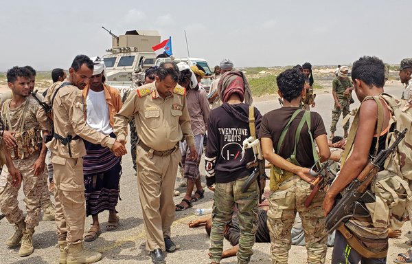 Brig. Gen. Abu Bakr Hussein Salem (3rd left), governor of Yemen's southern province of Abyan, and other security personnel inspect the bodies of members of al-Qaeda who were shot after attacking a security checkpoint of the UAE-trained Security Belt Forces in Ahwar district last September 6. [AFP]