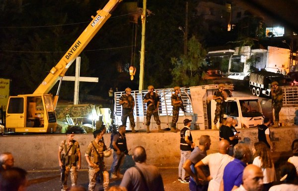 Lebanese soldiers and onlookers gather in the town of Kahale, where two people were killed August 9 in clashes between members of Iran-backed Hizbullah and residents of the town. [AFP]